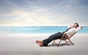 man sitting in lounge chair on the beach