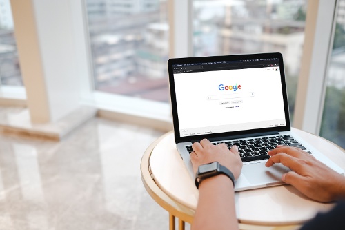 A man is typing on Google search engine from a laptop-1